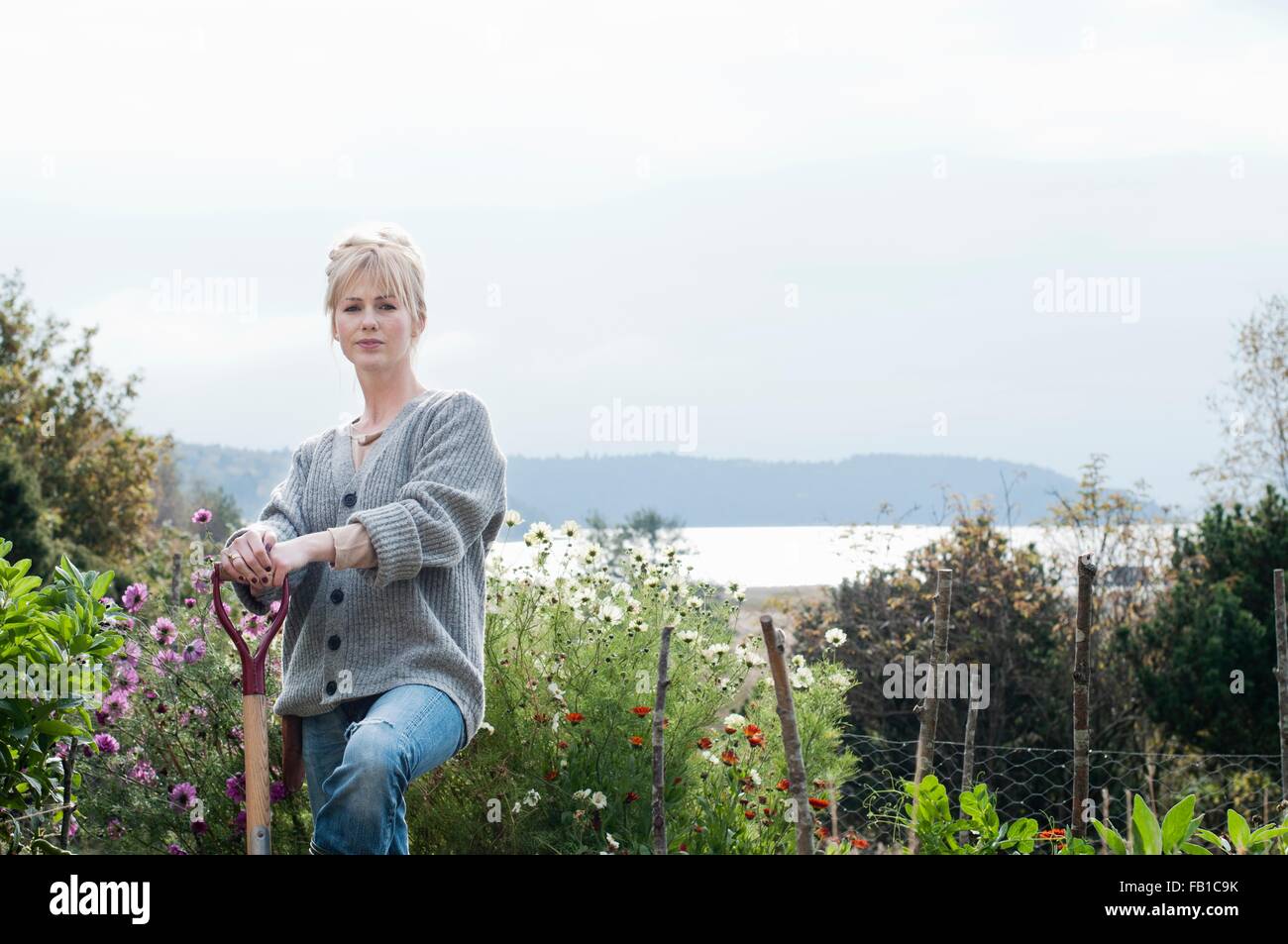 Portrait of mid adult woman digging in organic garden, Orust, Sweden Stock Photo