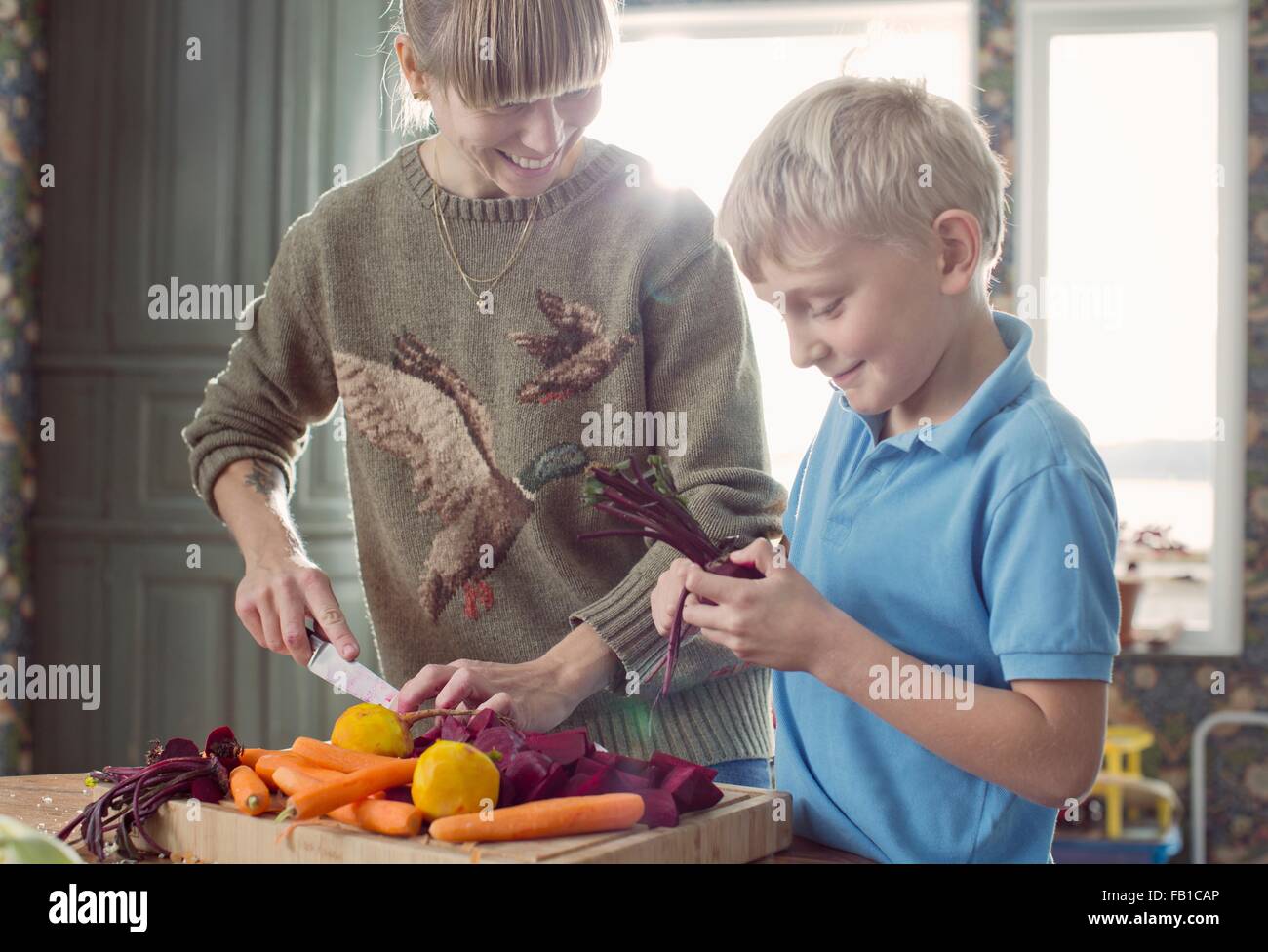 Mother and son preparing organic vegetables in kitchen Stock Photo