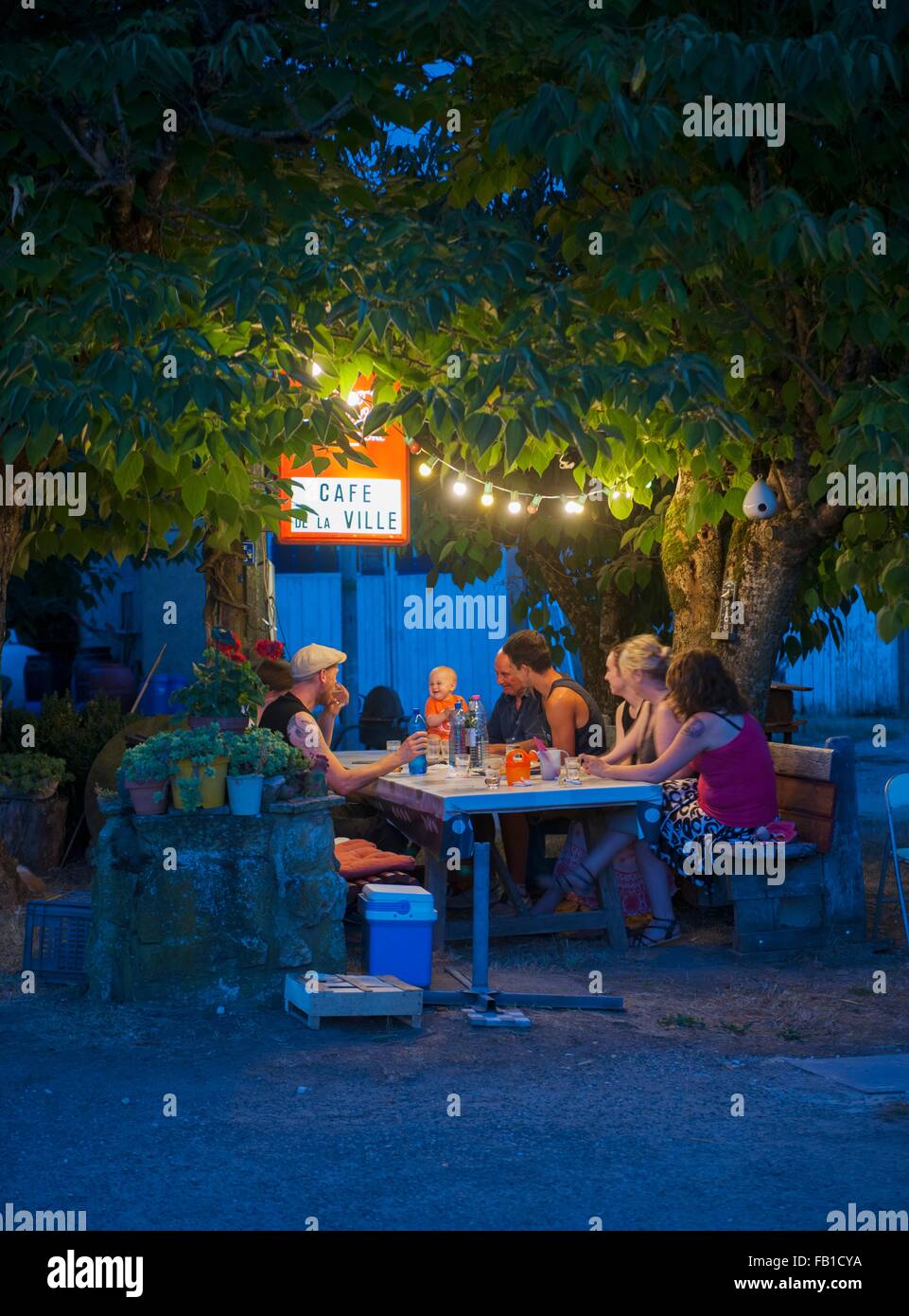 Three generation family at cafe table at night, France Stock Photo
