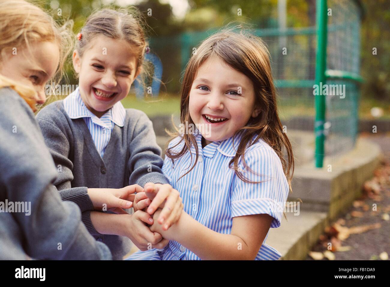 Elementary schoolgirls playing hand game in school playground Stock