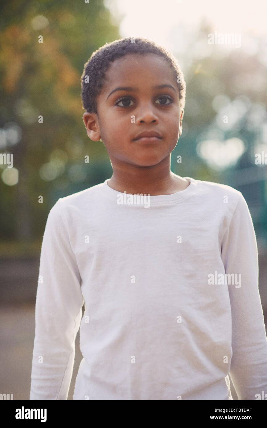 Portrait of elementary schoolboy standing in school playground Stock Photo