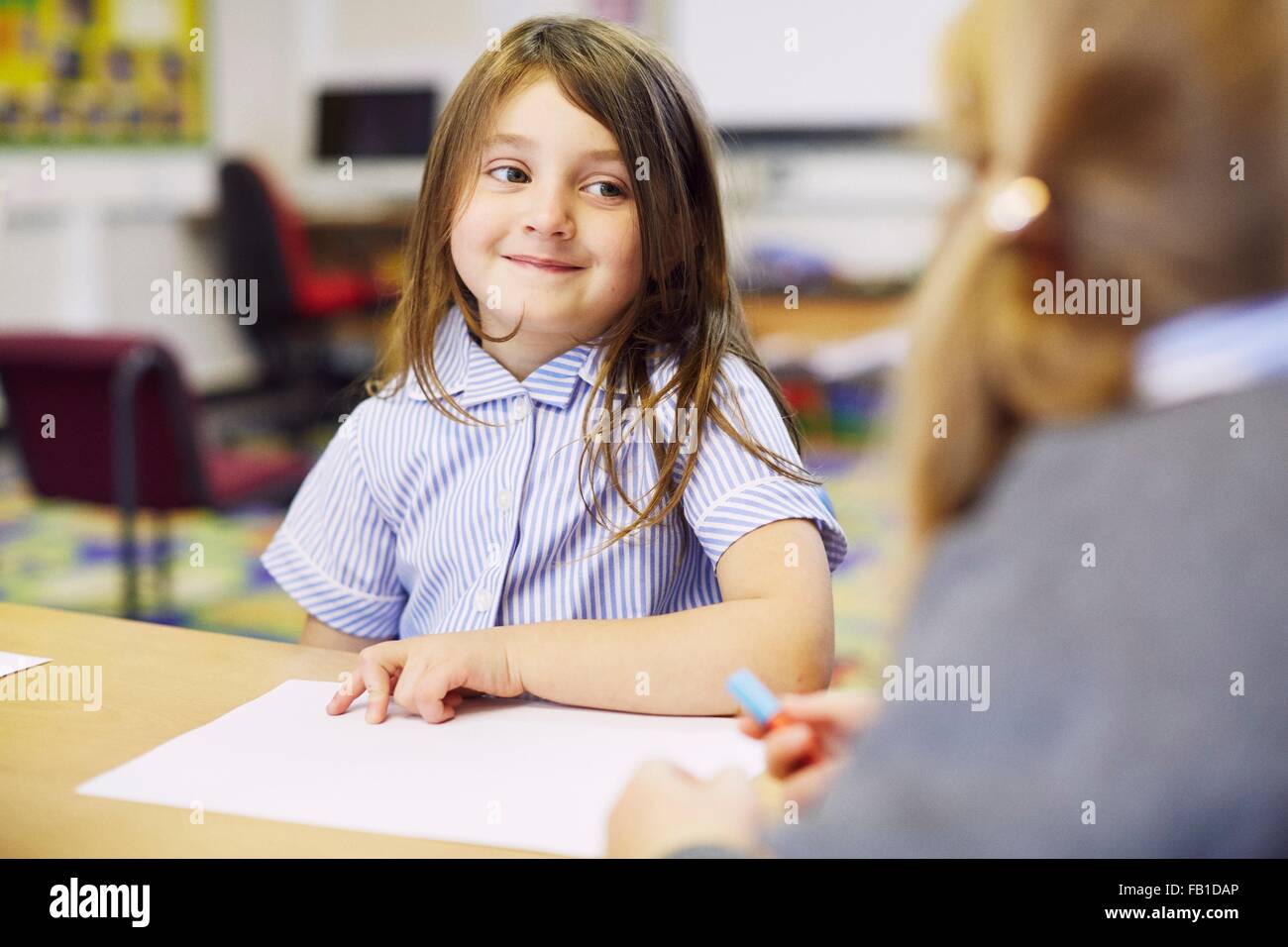 Two girls drawing at desk in elementary school classroom Stock Photo