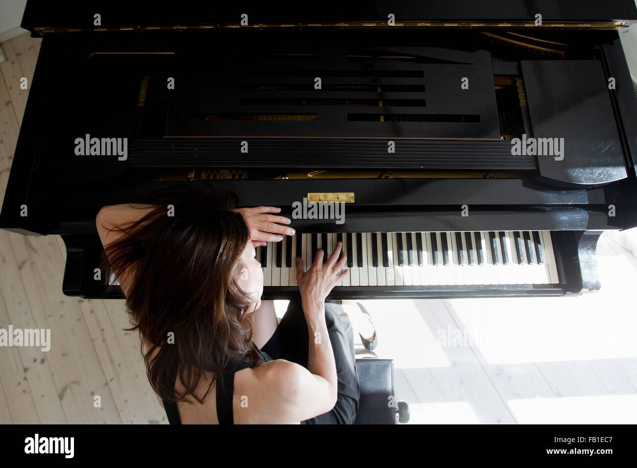 Listen she is playing the piano. Девушка облокотилась на пианино. Женщина у пианино. Пианино Прима фото. A woman playing the Piano.