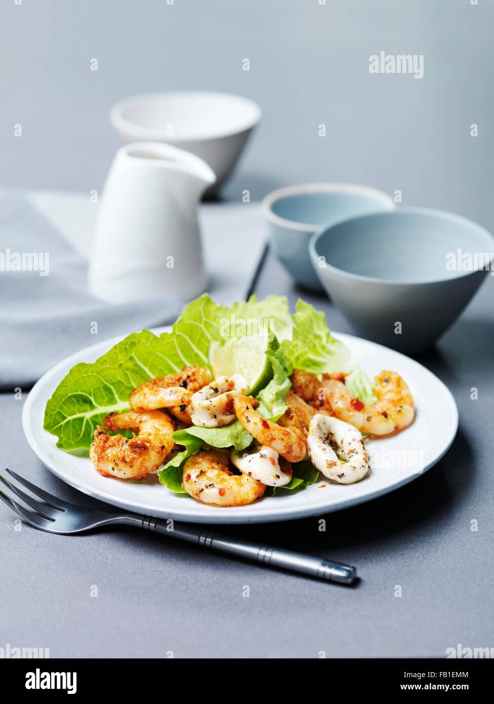 Tandoori prawns and chargrilled calamari with lime slice and lettuce Stock Photo