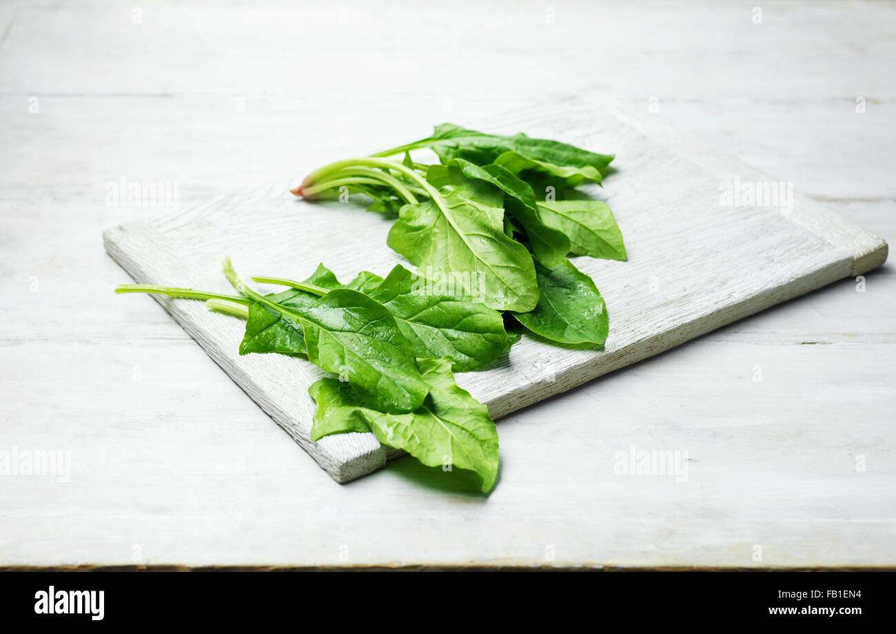 Whole leaf spinach on wooden chopping board Stock Photo Alamy