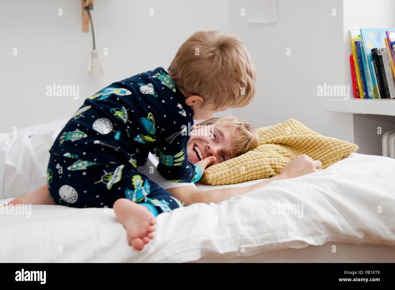 Young boy waking up father n bed Stock Photo