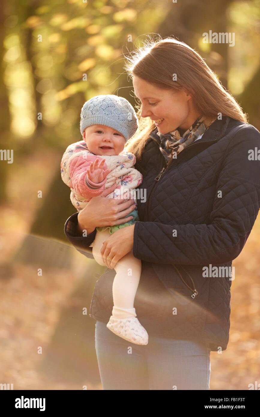 Portrait of mid adult woman and baby daughter in autumn park Stock Photo