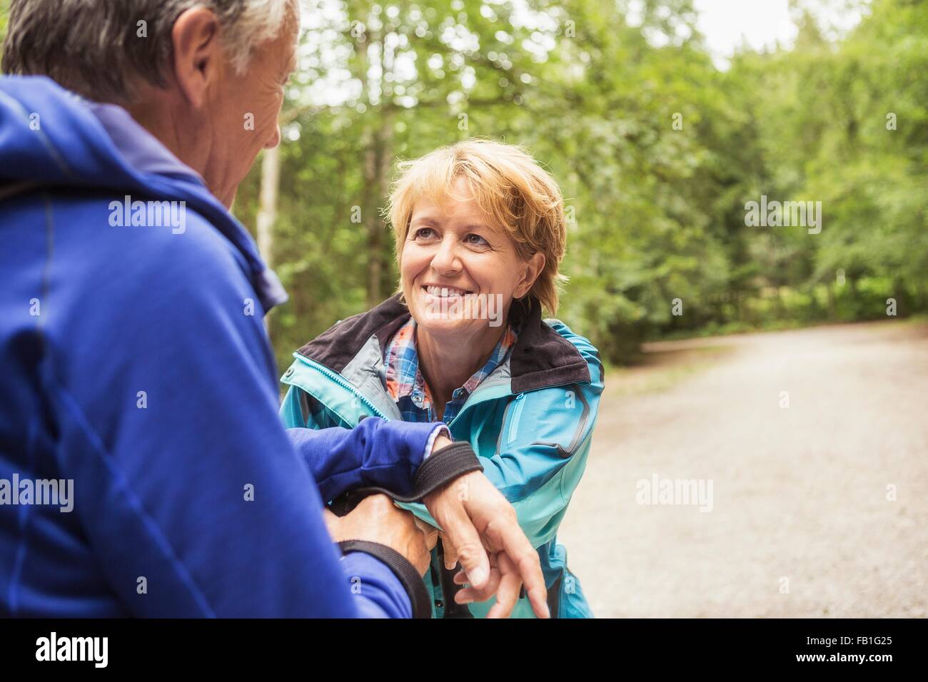Couple on pathway in forest, face to face, smiling Stock Photo