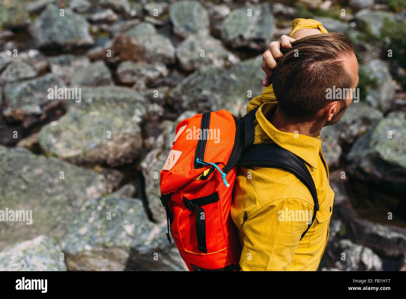 High angle view of mid adult man carrying orange colour backpack, Moraine lake, Banff National Park, Alberta Canada Stock Photo