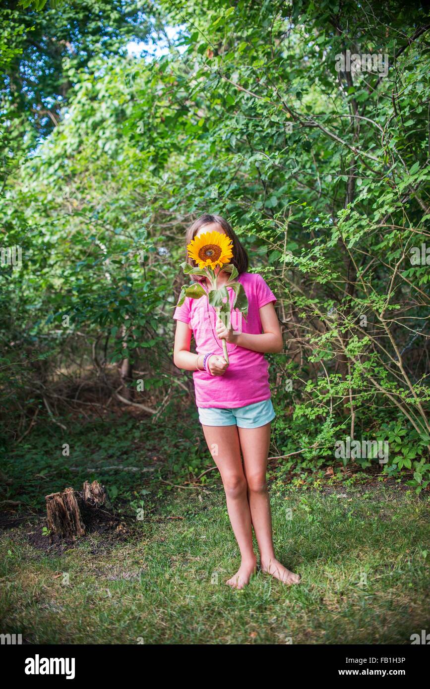 Young girl holding sunflower in front of face Stock Photo