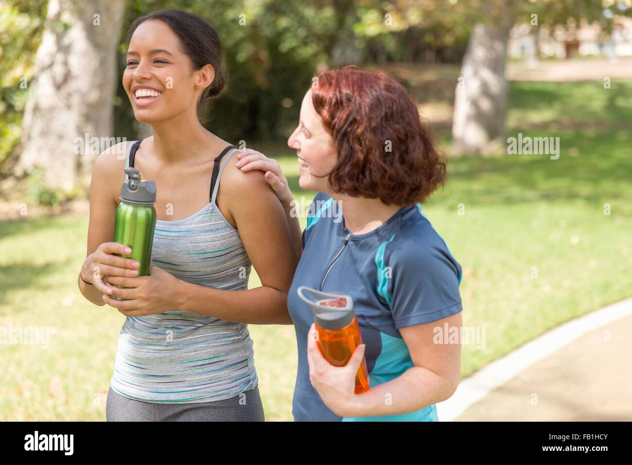 High angle view of young women out walking wearing sports clothing carrying water bottles smiling Stock Photo