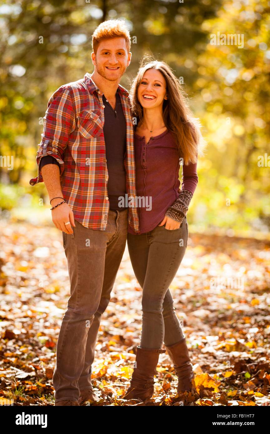 Sunlit portrait of young couple in autumn forest Stock Photo - Alamy