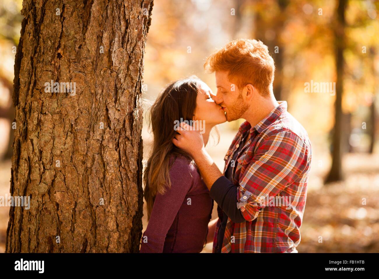 Romantic young couple kissing in autumn forest Stock Photo