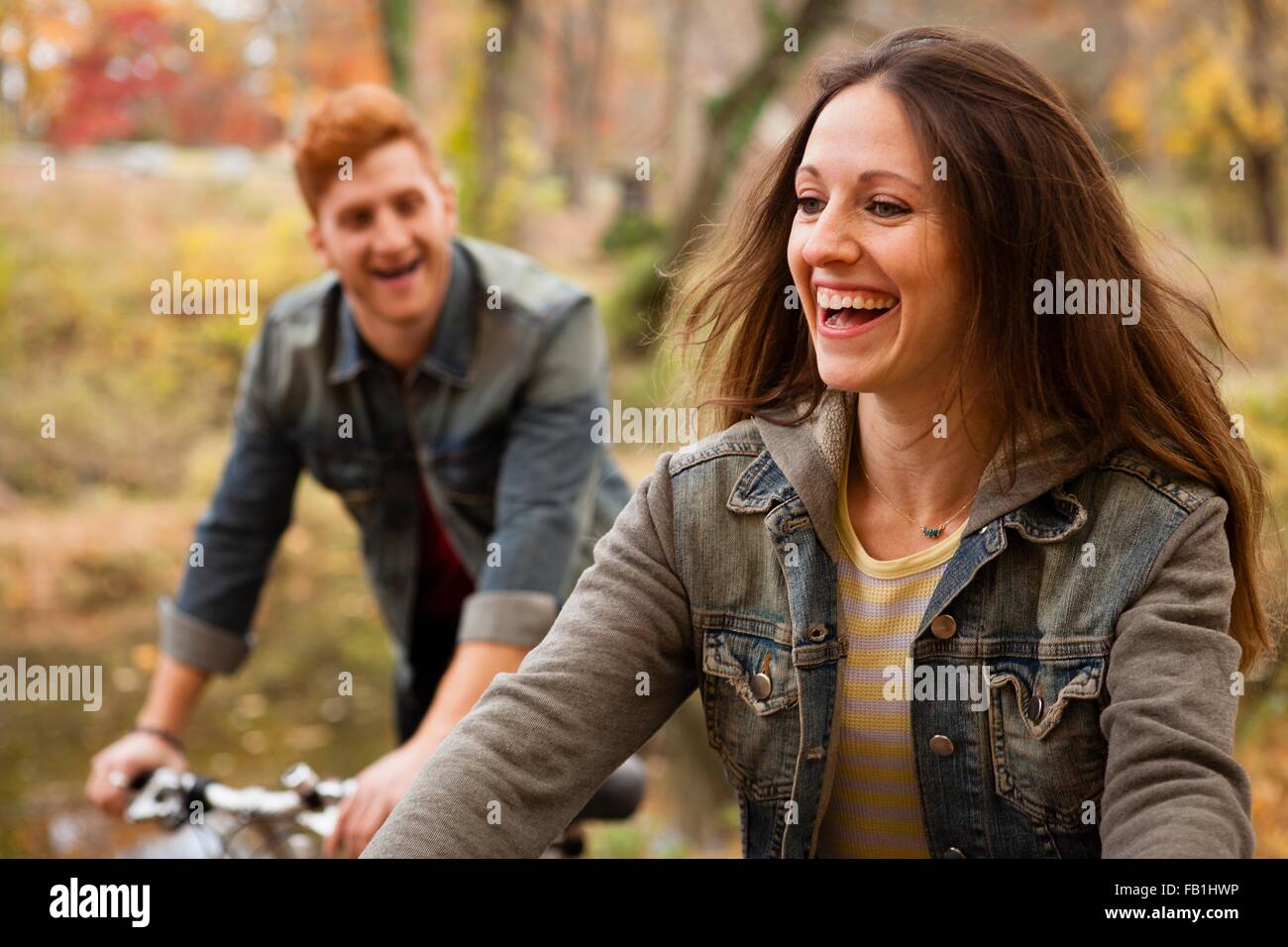 Young couple cycling along riverside in autumn Stock Photo