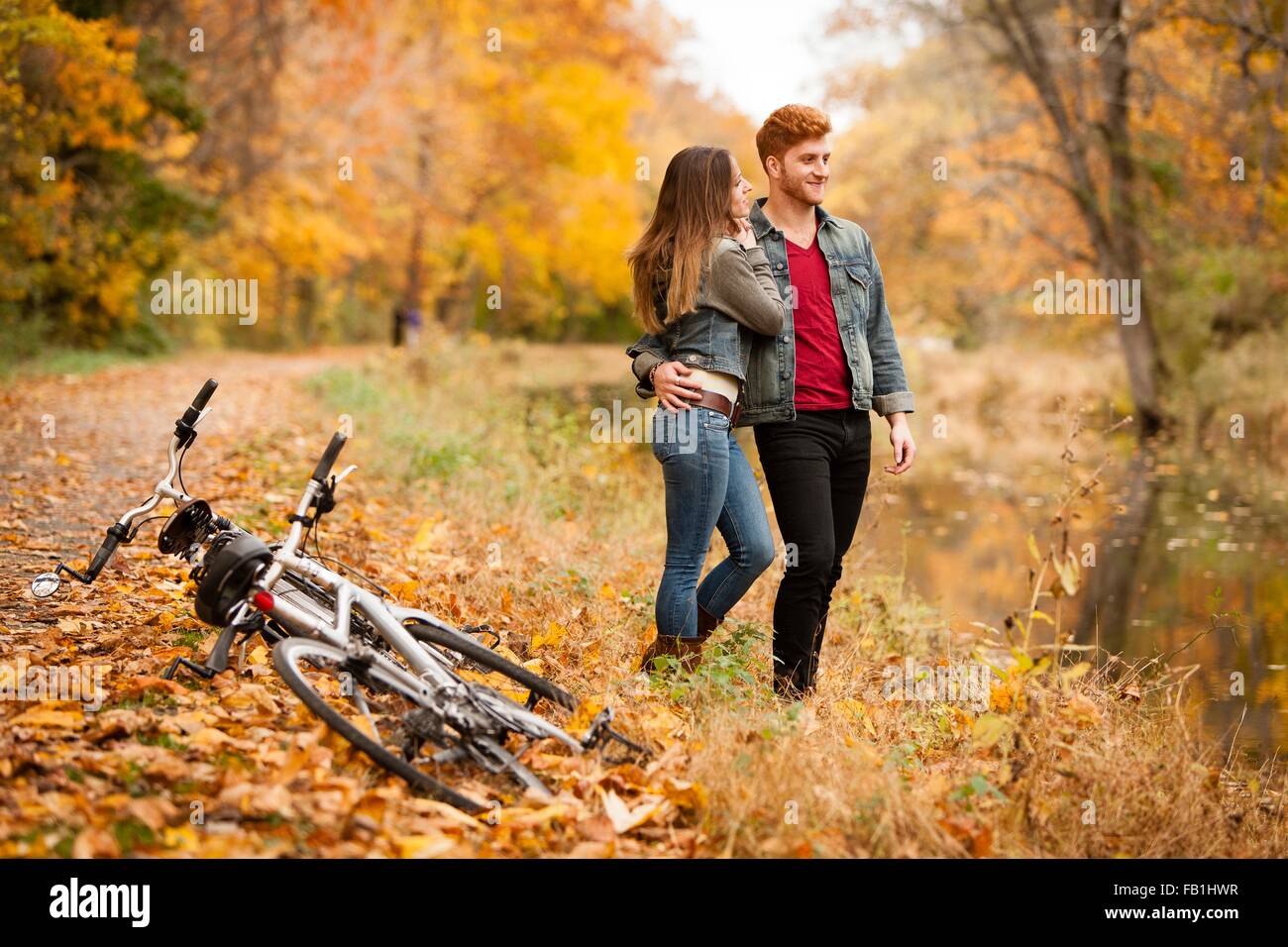 Romantic young couple on riverside in autumn Stock Photo - Alamy