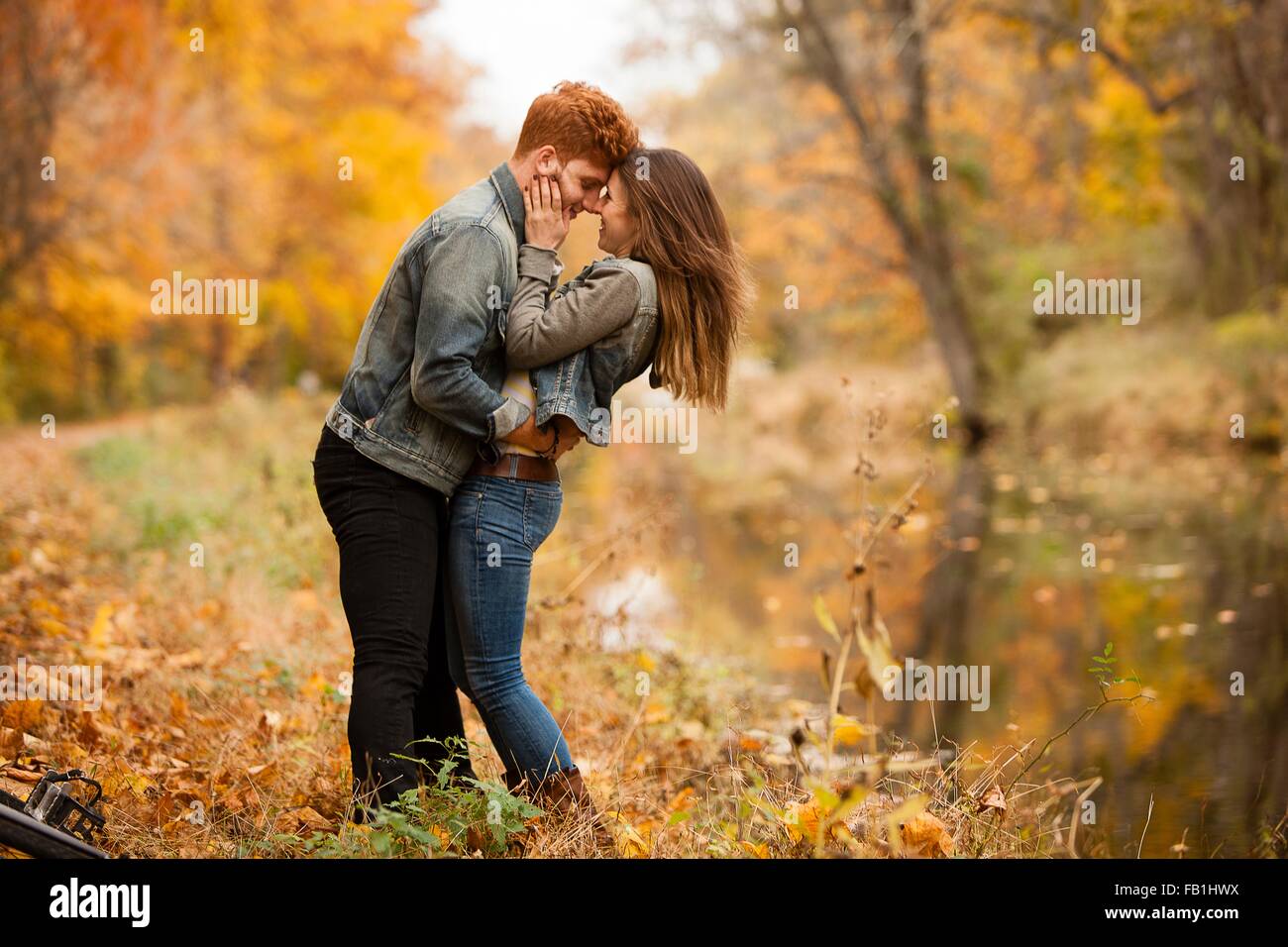 Romantic young couple on riverside in autumn Stock Photo - Alamy