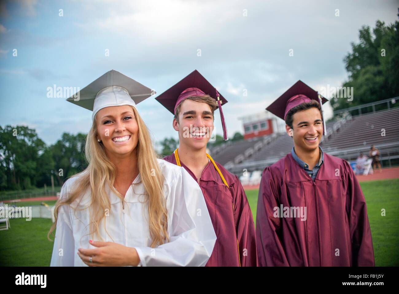 Young female and male graduates at graduation ceremony Stock Photo