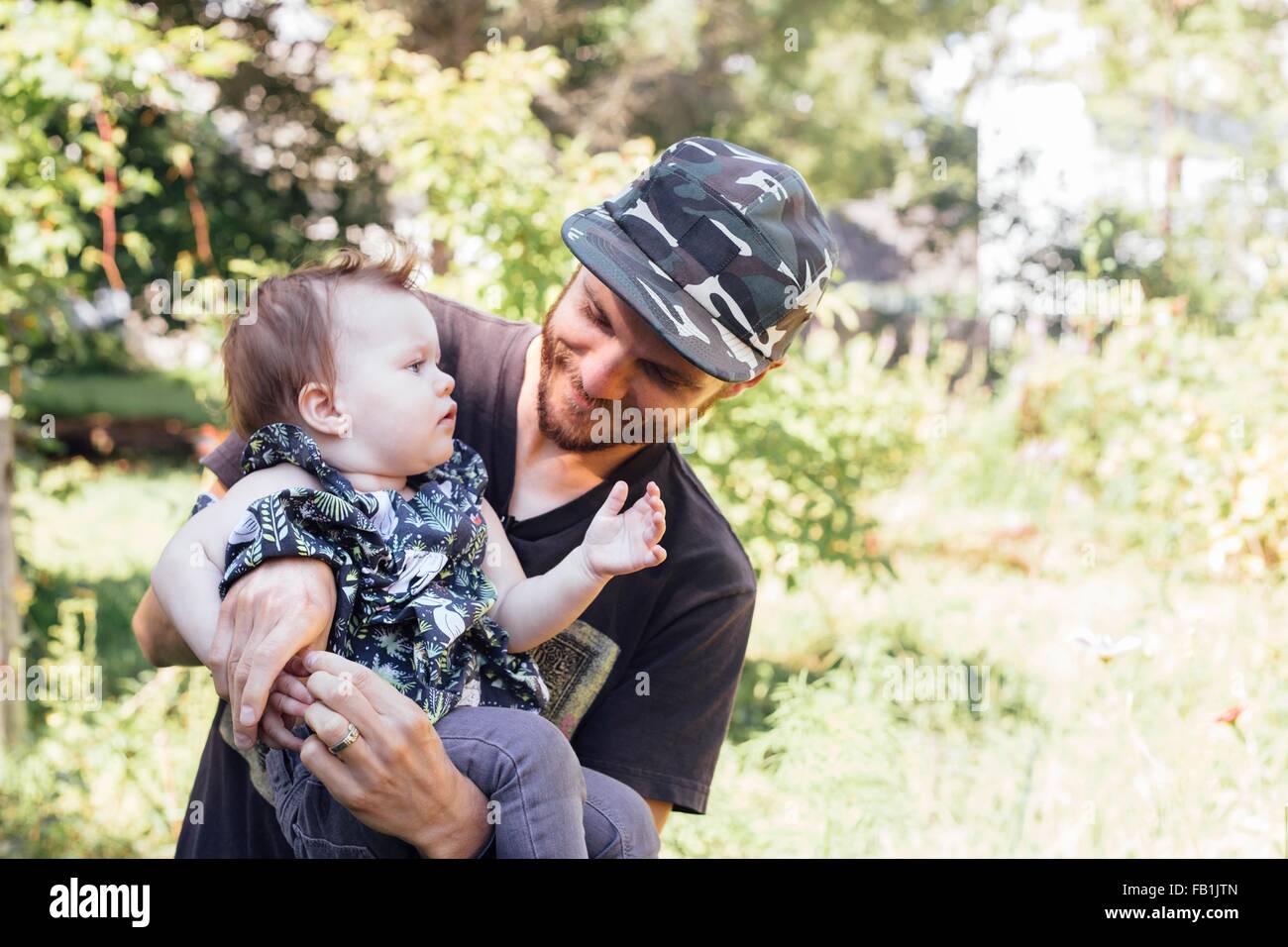 Mid adult man carrying baby daughter in woodland Stock Photo