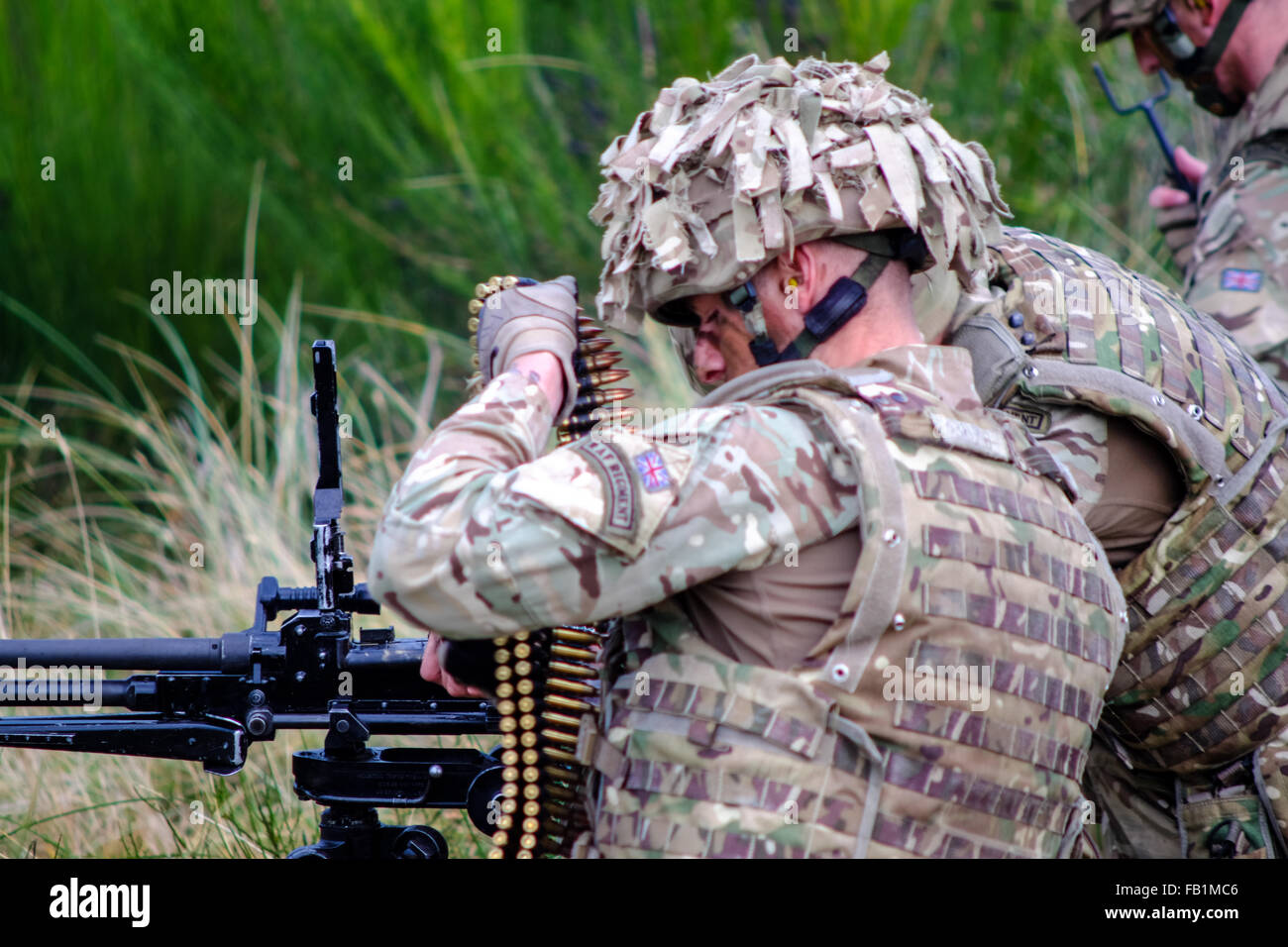 A Royal Air Force RAF regiment soldier loads a machine gun during a drill at Fort George, Scotland. Stock Photo