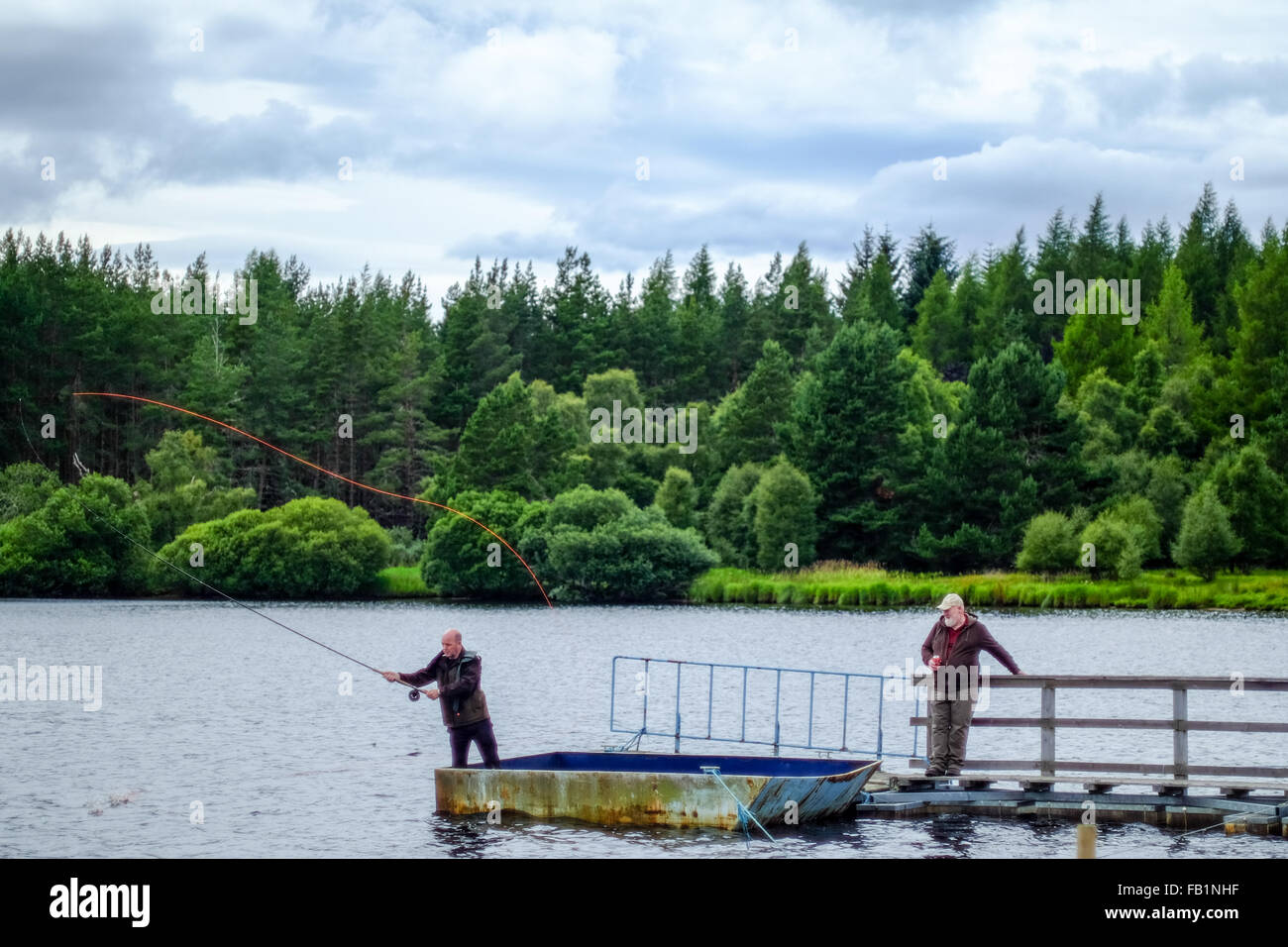 Scottish men fly fishing on a pier in Moy, in the highlands of Scotland