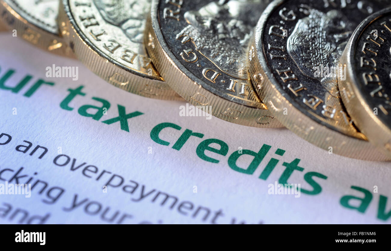 GOVERNMENT TAX CREDITS INFORMATION FORM WITH ONE POUND COINS RE INCOMES LOW WAGES MINIMUM WAGE BENEFITS FAMILY INCOMES MONEY UK Stock Photo