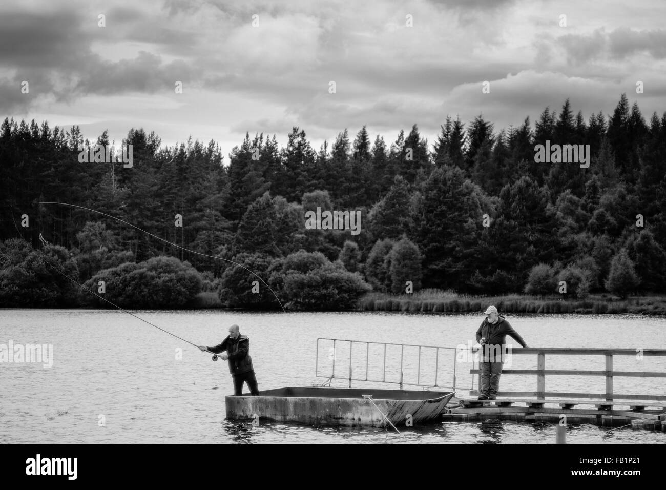 Scottish men fly fishing on a pier in Moy, in the highlands of Scotland
