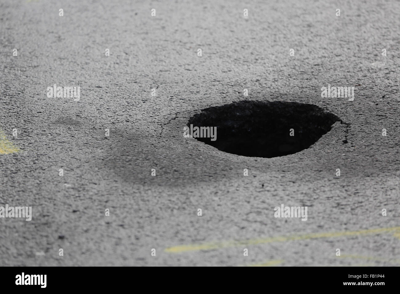 Neath, UK. Thursday 07 January 2016 The sinkhole in Cimla Road, Neath Re: A sinkhole up to 10ft deep has appeared in Neath. south Wales, leading to the closure of a main road. Police have sealed off Cimla Road, in Neath, following the discovery at the bottom of Cimla Hill. South Wales Police and Neath Port Talbot council workers are currently at the scene assessing the damage and preparing to carry out emergency repairs. Credit:  D Legakis/Alamy Live News Stock Photo