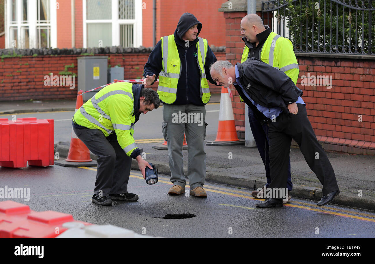 Neath, UK. Thursday 07 January 2016 Council officials by the sinkhole in Cimla Road, Neath Re: A sinkhole up to 10ft deep has appeared in Neath. south Wales, leading to the closure of a main road. Police have sealed off Cimla Road, in Neath, following the discovery at the bottom of Cimla Hill. South Wales Police and Neath Port Talbot council workers are currently at the scene assessing the damage and preparing to carry out emergency repairs. Credit:  D Legakis/Alamy Live News Stock Photo