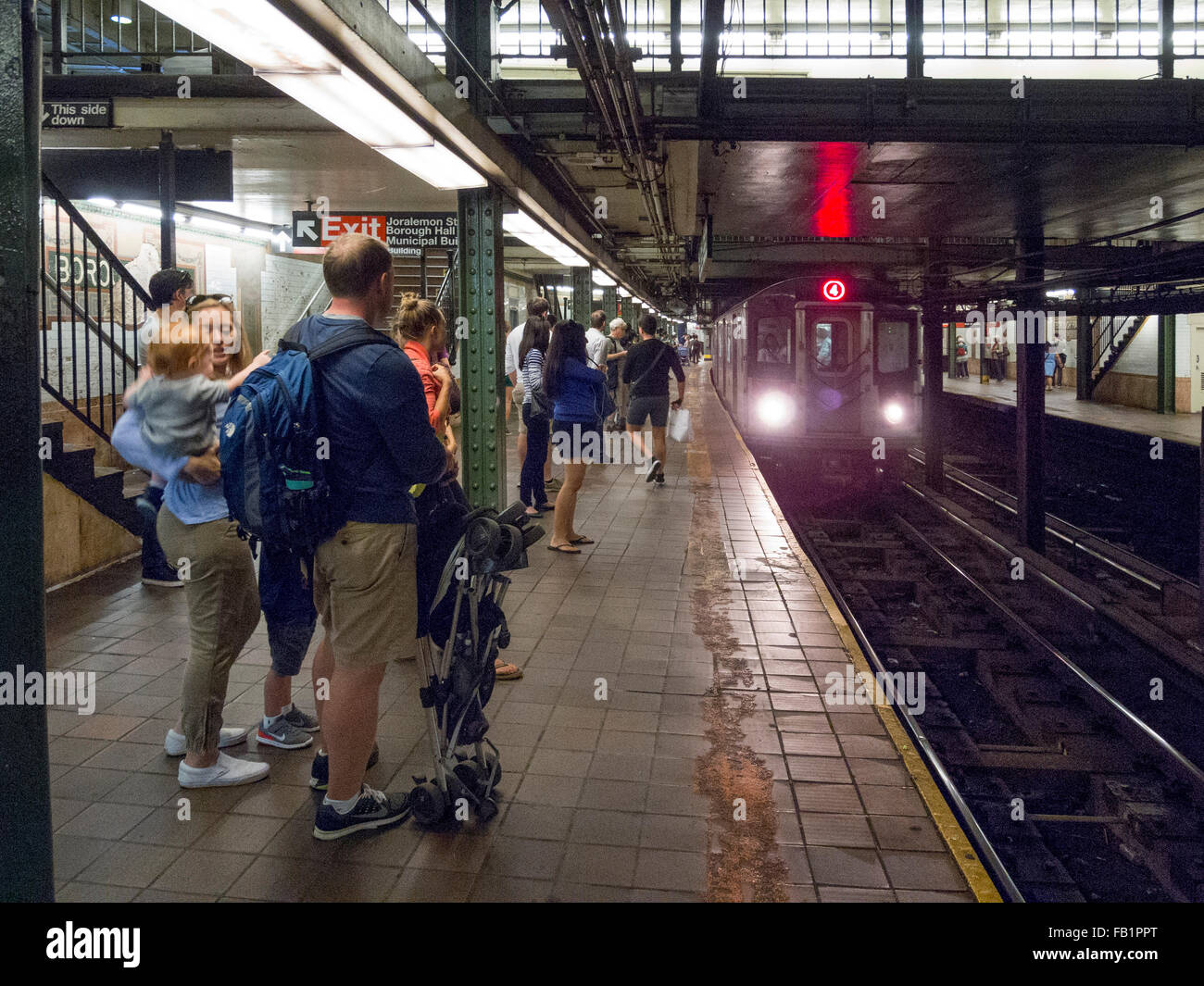 Passengers await the arrival of a subway train at Borough Hall station