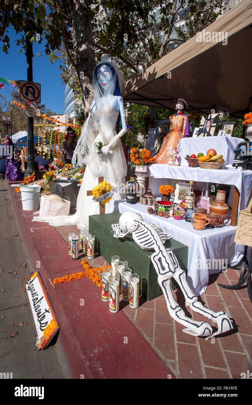 An altar honoring a deceased family member is exhibited on the Mexican Day of the Dead or Dia des Muertos in a Hispanic neighborhood in Santa Ana, CA. Note skeleton or calavera, bridal figure, and framed portrait of the deceased family member at right and Stock Photo
