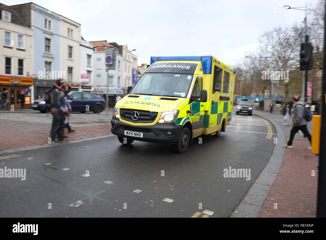 Yellow British Ambulance on a blue light run in the centre of Bristol