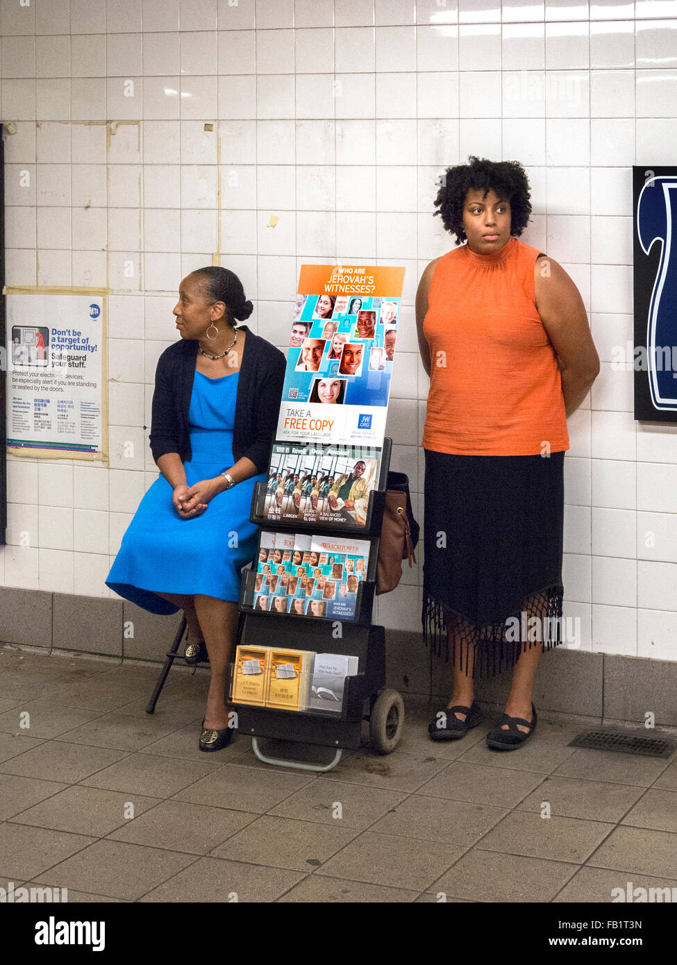 African American Jehovah's Witnesses accompany an information display in a New York City subway station. Note brochures. Stock Photo