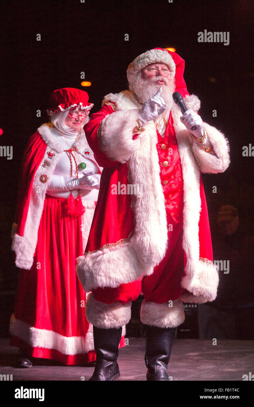 In full costume, Santa Claus and Mrs. Santa appear at a Christmas holiday festival at night in Laguna Niguel, CA. Stock Photo