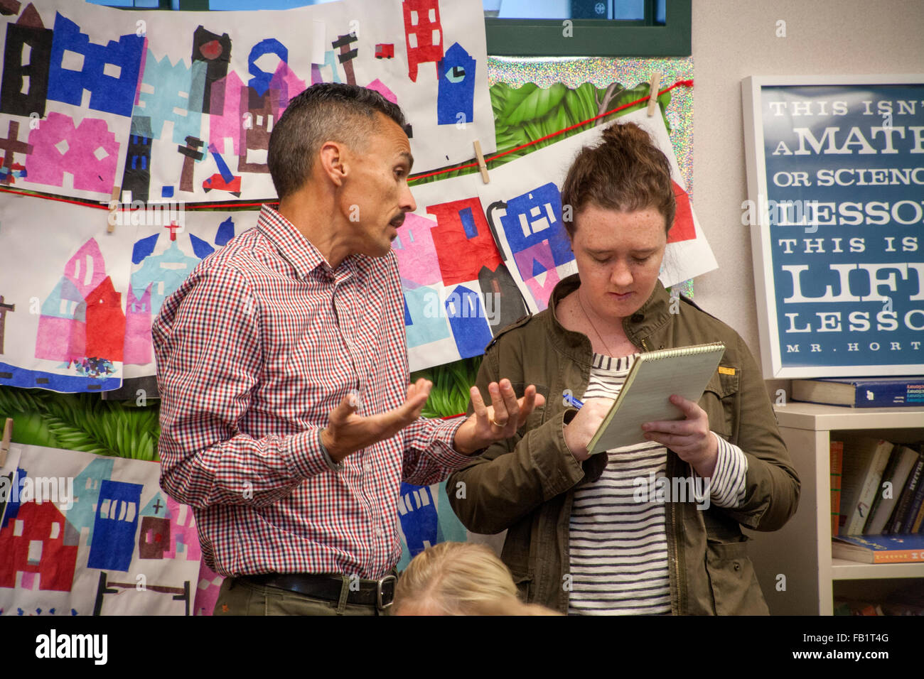 A Young Female Newspaper Reporter Interviews Hispanic Fifth Grade Teacher At San Clemente CA Elementary School Note Sign Right A Young Female Newspaper Reporter Interviews Hispanic Fifth Grade Teacher At San Clemente CA Elementary School Note Sign Right