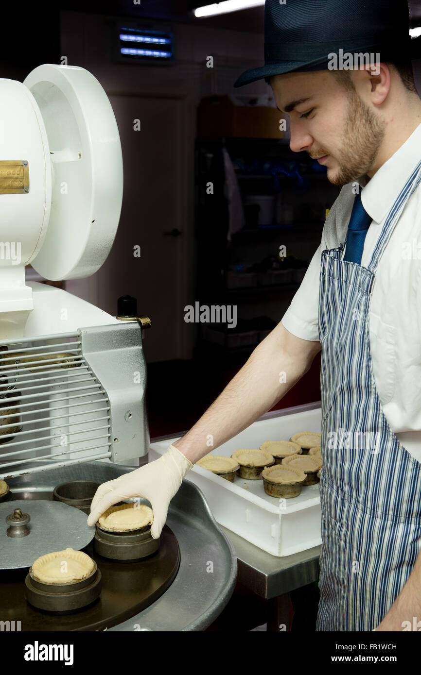 https://c8.alamy.com/comp/FB1WCH/a-man-making-pork-pies-in-a-factory-with-an-automated-machine-FB1WCH.jpg