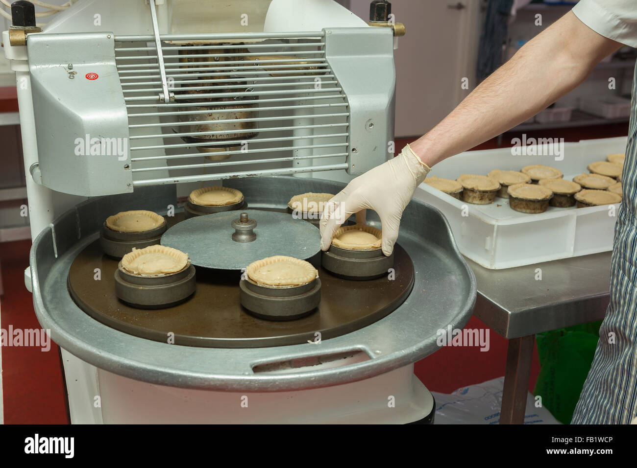https://c8.alamy.com/comp/FB1WCP/a-man-making-pork-pies-in-a-factory-with-an-automated-machine-FB1WCP.jpg