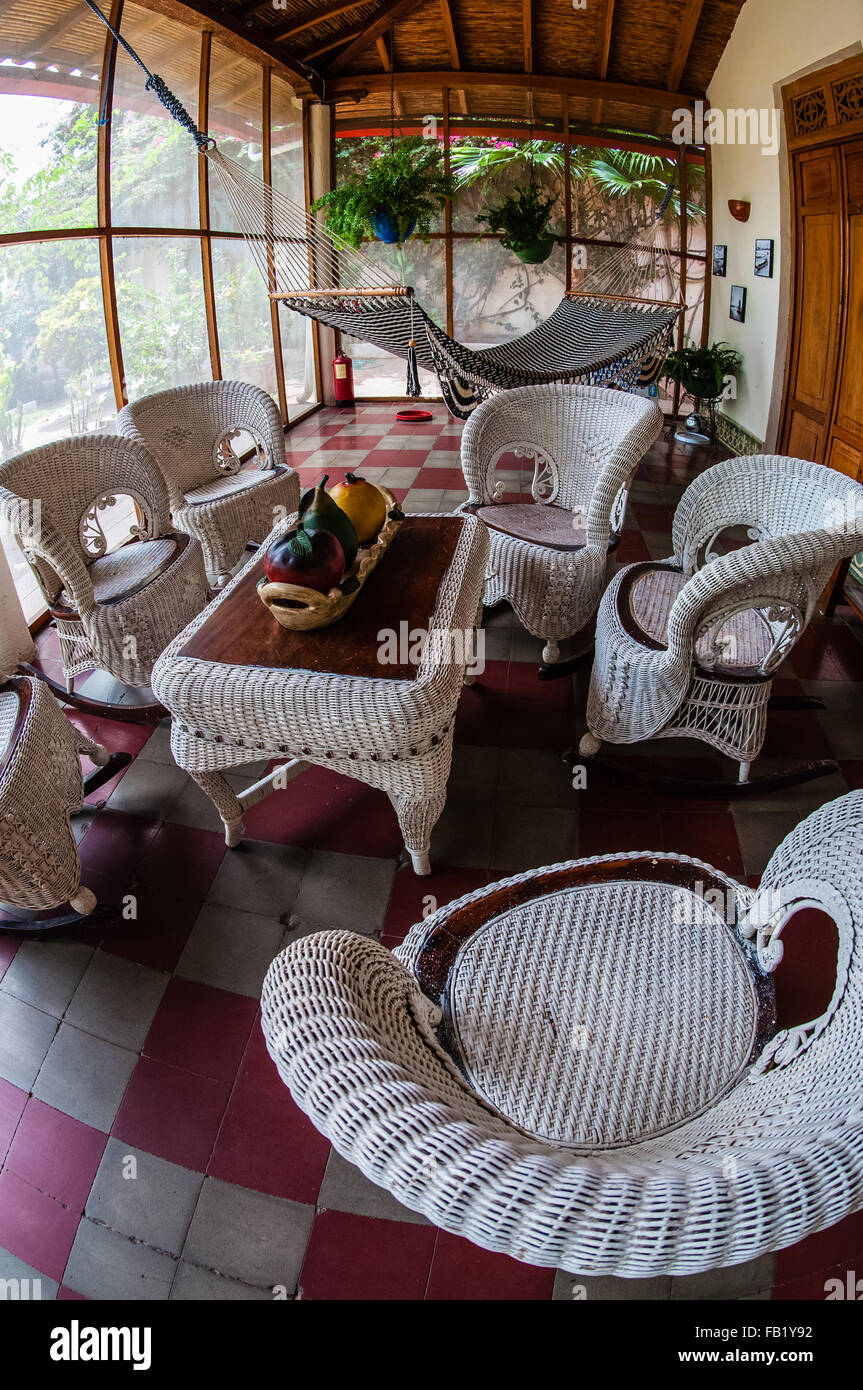 White rattan furniture on tiled floor in a hostel Stock Photo