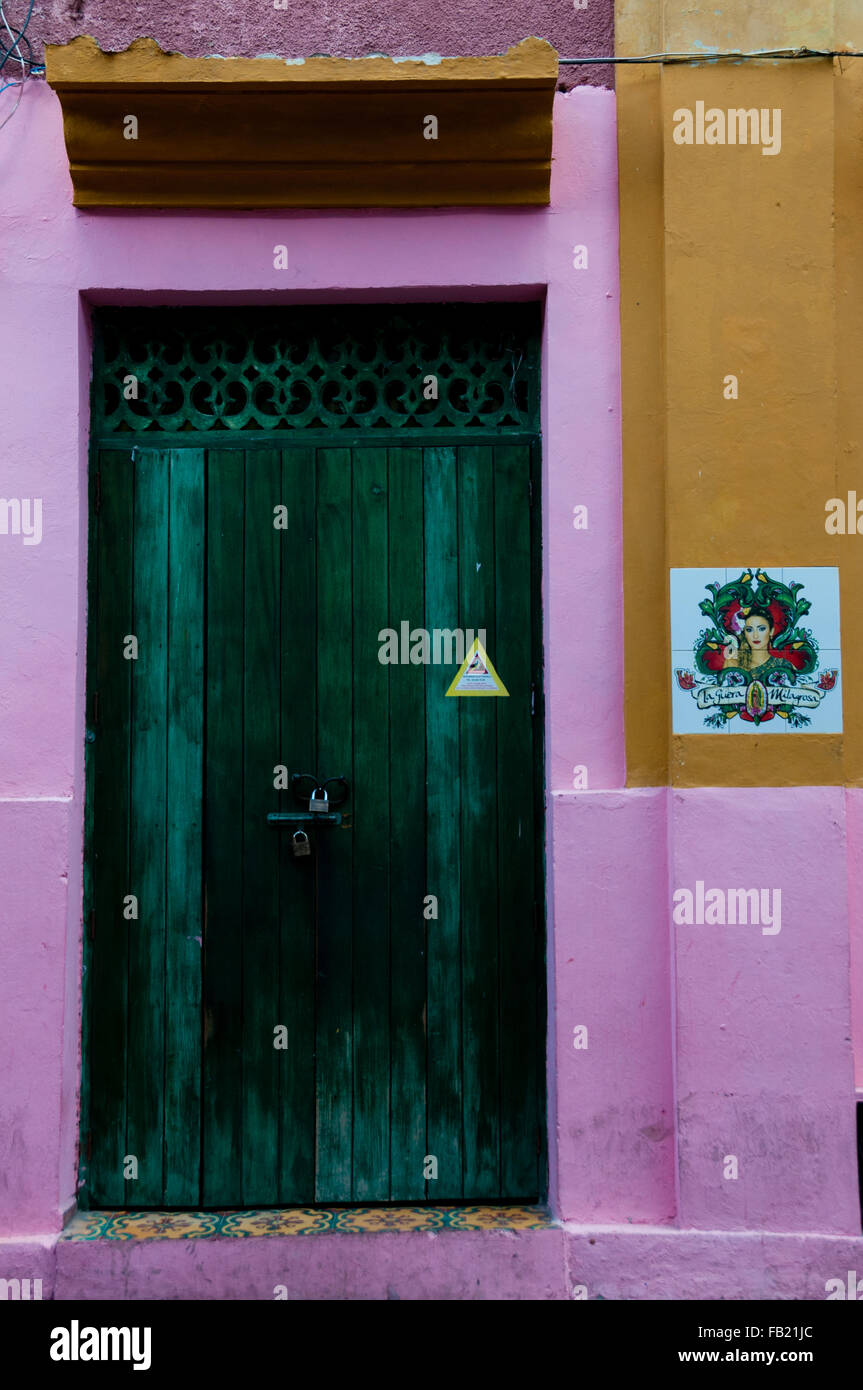 Green wooden door of a pink yellow colonial house front Cartagena Stock Photo