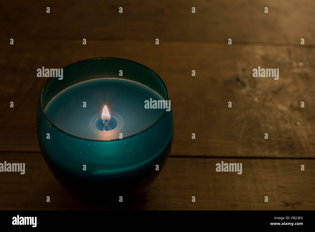 Blue Candle Lit on a Wooden Table Stock Photo Alamy