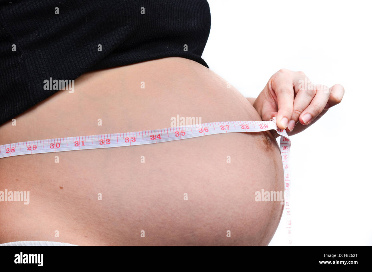 Woman holding her pregnant belly. White background Stock Photo - Alamy