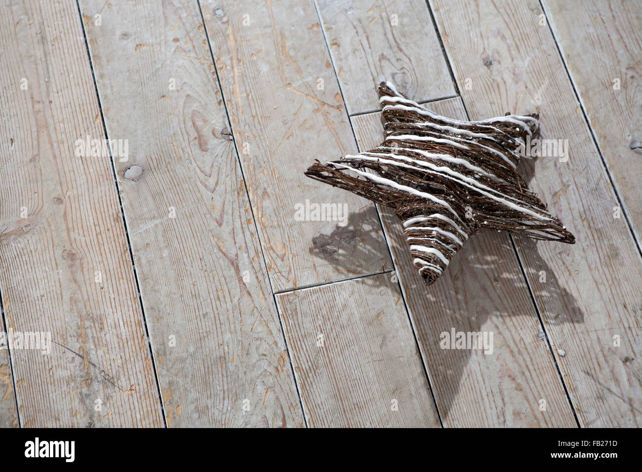 white and brown star with huge shadow on the wood floor Stock Photo