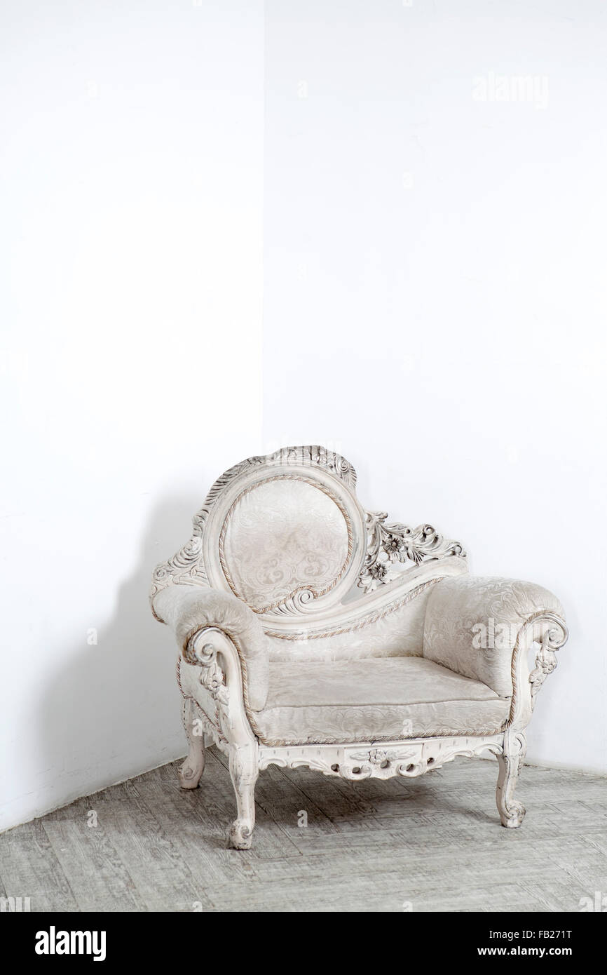 Beautiful antic armchair from solid wood in white interiour Stock Photo