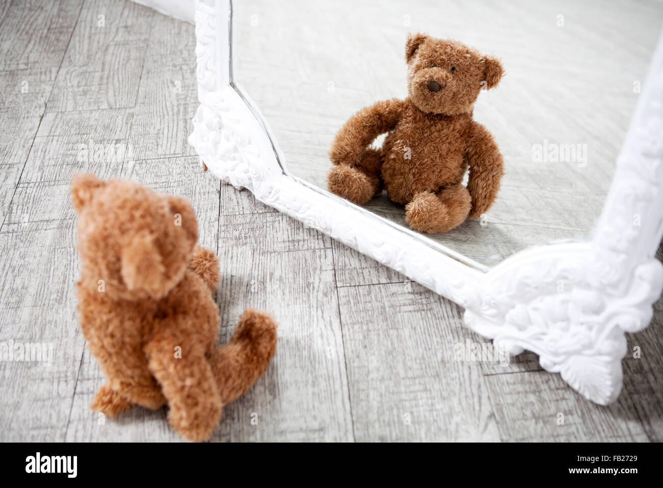 Pretty old vintage Teddy Bear toy looking at the mirror Stock Photo - Alamy