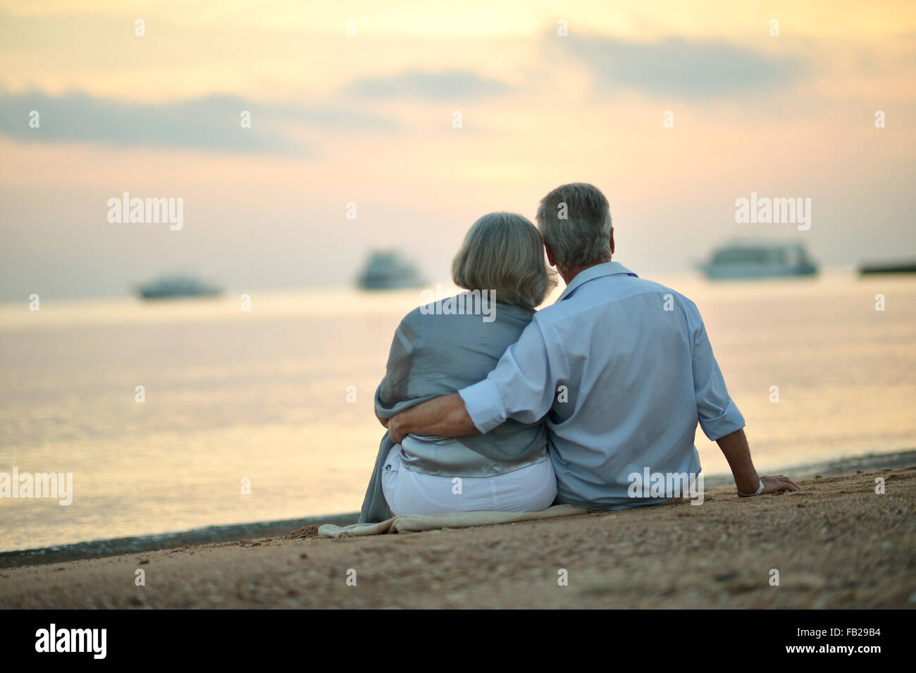 Mature couple relaxing on beach Stock Photo - Alamy