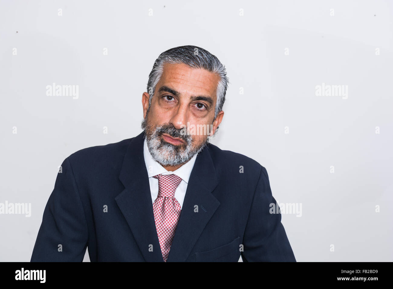Handsome businessman in his studio, in suits, bearded, grizzled. Stock Photo