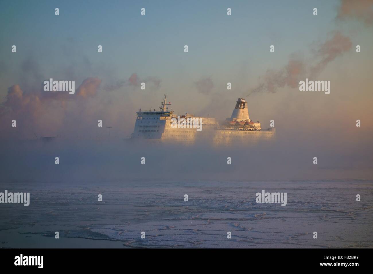 Ferry  arriving to Helsinki harbor on a cold winter morning in the middle of sea smoke Stock Photo