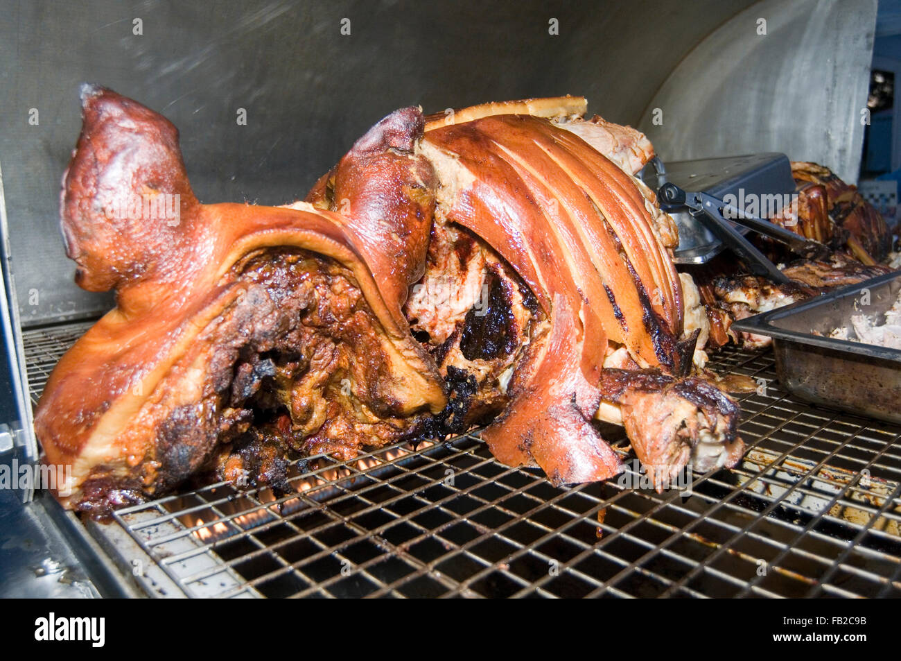 hog roast roasts meat pork pig head roasted meats head carcass open flame flames roast roasting well cooked red hogroast hogroas Stock Photo