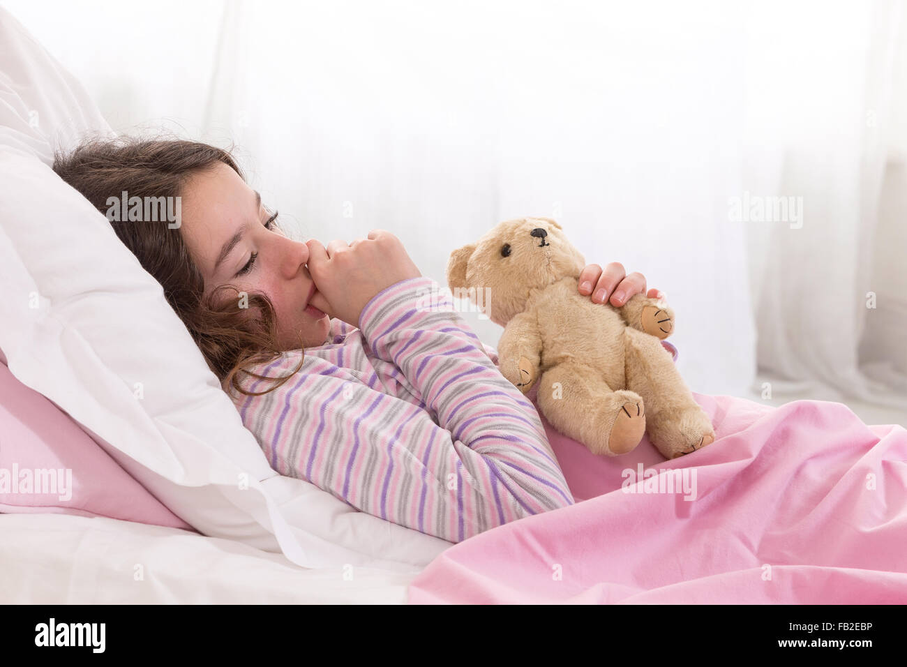 Young Teenager Asleep in Bed with Teddy Bear Stock Photo