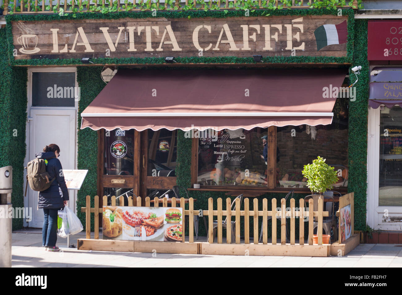 Woman looking at the menu outside La Vita Caffe at Southampton, Hampshire UK in March Stock Photo