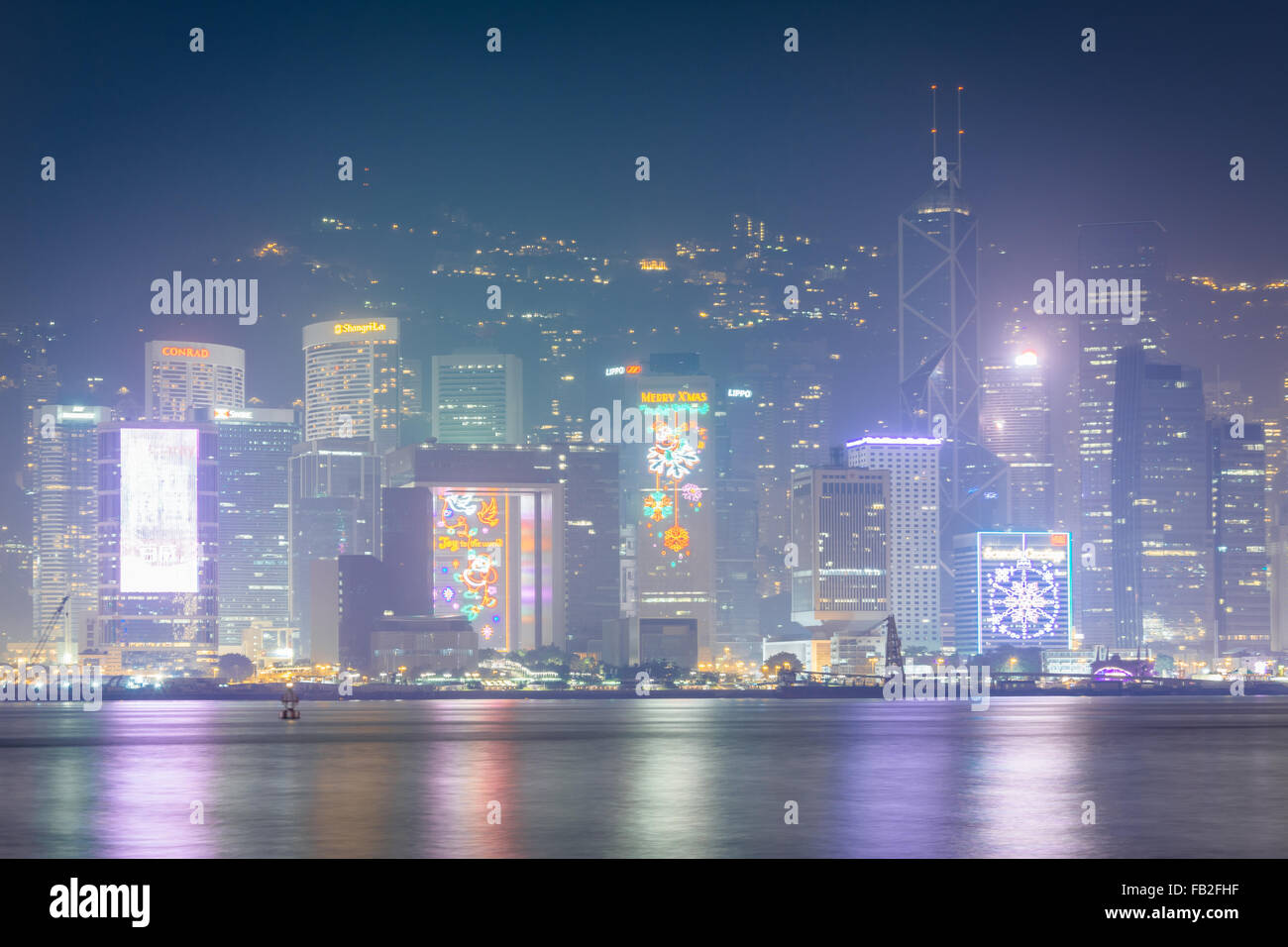 View of modern skyscrapers on Hong Kong Island at night, from Tsim Sha Tsui, in Kowloon, Hong Kong. Stock Photo